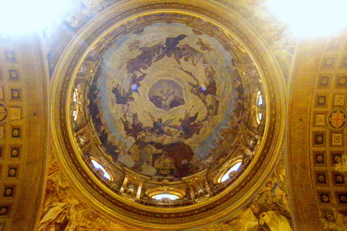 The painted dome seen from below, ringed by gilded decoration and coffered arches.