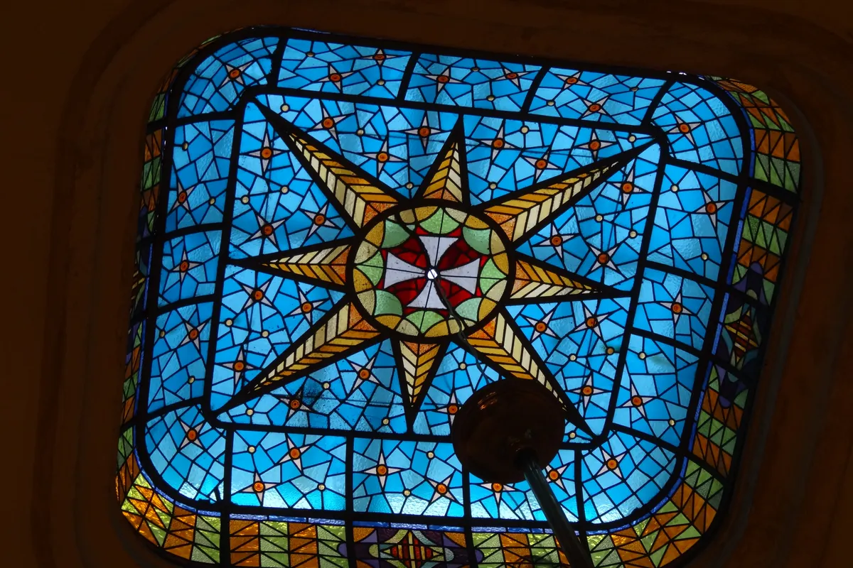 A blue stained-glass skylight in the basilica's ceiling with a star pattern.